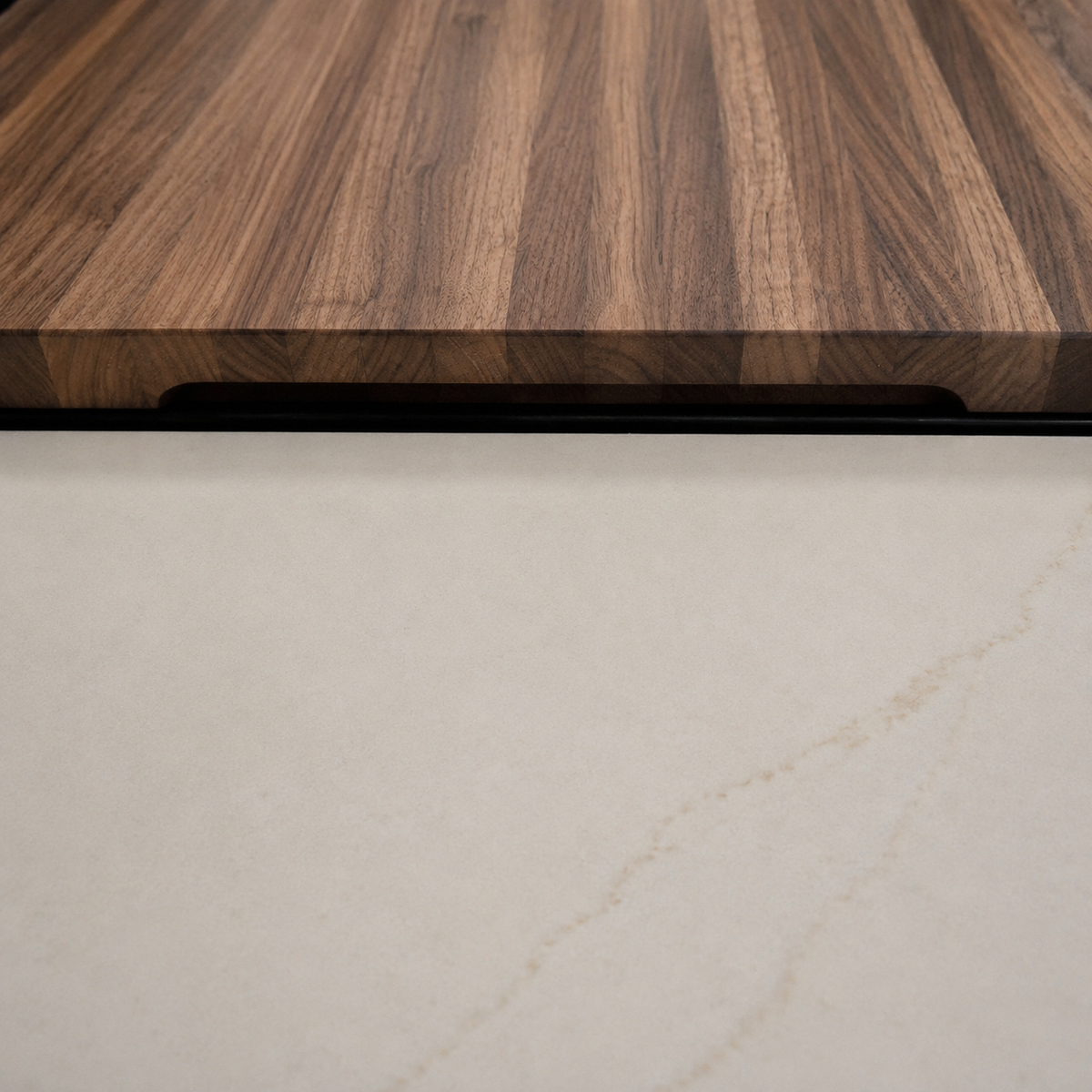 Close-up of The Canopy walnut stove top cover with a concealed recessed grip