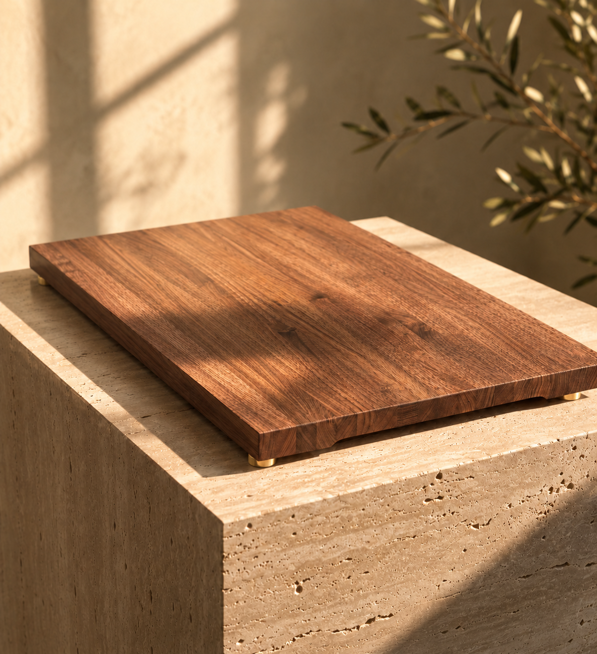 The Prestige walnut cutting board displayed on a stone pedestal with gold feet