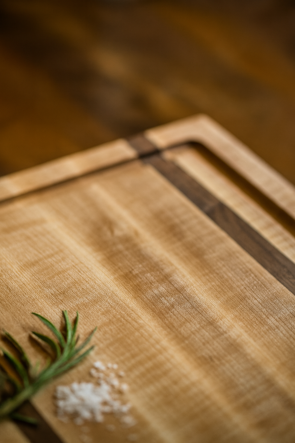 Corner detail of The Double Barrel maple and walnut cutting board showing juice groove craftsmanship