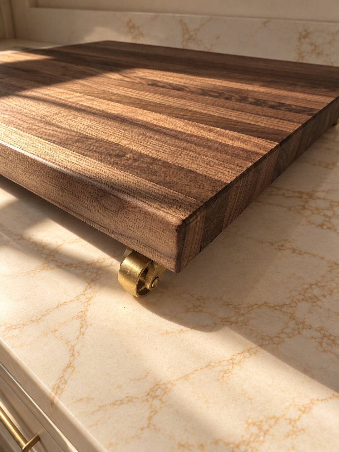 Close-up of The Press walnut edge and solid brass caster wheel